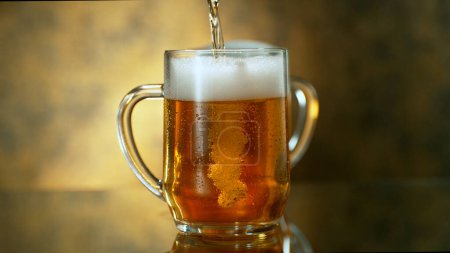 Foto de Freshly brewed beer in a pint on orange gradient background, close-up - Imagen libre de derechos