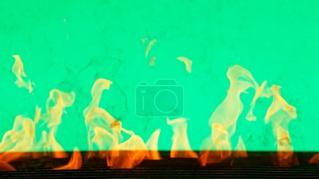 Foto de Llama de fuego con rejilla de hierro fundido aislada sobre fondo de pantalla verde - Imagen libre de derechos