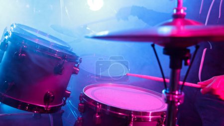 Photo for A drummer plays on a dark stage in the fog and neon lights. - Royalty Free Image