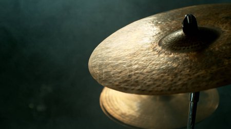 Téléchargez les photos : Gros plan d'un batteur joue sur une cymbale, fond sombre - en image libre de droit