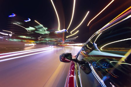 Photo for Blurred urban look from fast driving car to back side and driver at summer night. Longexposure shot. - Royalty Free Image