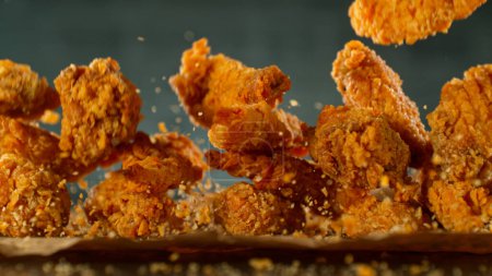 Foto de Congelar movimiento de tiro de vuelo sabroso pollo frito alas o tiras - Imagen libre de derechos