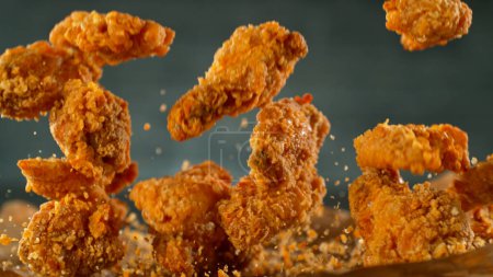 Téléchargez les photos : Tournage au gel des ailes ou des lanières de poulet frit volantes - en image libre de droit