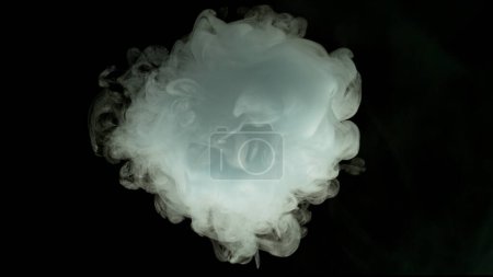 Téléchargez les photos : Petite boule de fumée blanche isolée sur fond noir - en image libre de droit