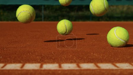 Téléchargez les photos : Balles de tennis rebondissantes sur un terrain d'argile, mouvement de gel - en image libre de droit