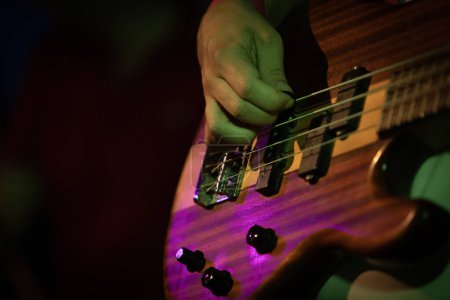 Photo for Bass guitar player or guitarist playing music instrument focus on hand - Royalty Free Image