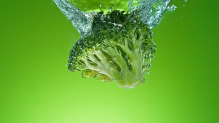 Téléchargez les photos : Congeler le mouvement de chute de brocoli frais dans l'eau - en image libre de droit