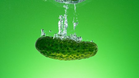 Téléchargez les photos : Congeler le mouvement de chute de concombre frais dans l'eau - en image libre de droit