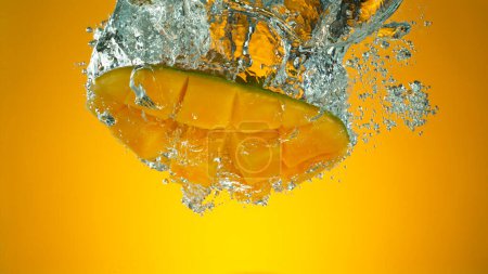 Téléchargez les photos : Congeler le mouvement de chute des mangues fraîches dans l'eau - en image libre de droit