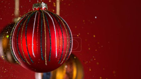 Téléchargez les photos : Boules de Noël décoratives avec lumières Bokeh et paillettes tombant - en image libre de droit