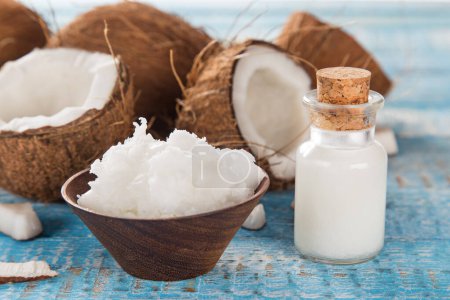 Photo for Coconut and coconut oil on old wooden table, close-up - Royalty Free Image
