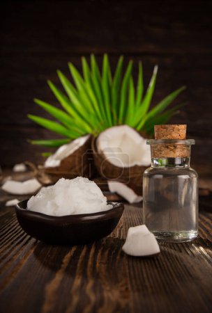 Photo for Coconut and coconut oil on old wooden table, close-up - Royalty Free Image