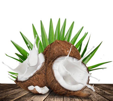 Photo for Cracked coconuts with splashing milk on old wooden table - Royalty Free Image