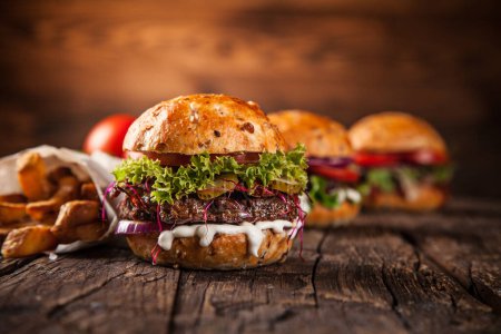 Téléchargez les photos : Hamburger fait maison avec laitue et fromage sur une vieille table en bois - en image libre de droit