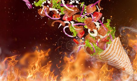 Photo for Close-up of kebab sandwich with flying ingredients. Freeze motion. - Royalty Free Image