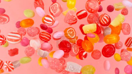 Téléchargez les photos : Freeze motion of flying various kind of candies. Colored abstract sweet background. - en image libre de droit
