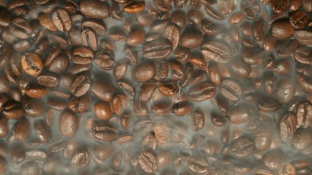 Téléchargez les photos : Torréfaction des grains de café avec de la fumée imprégnant entre les grains - en image libre de droit