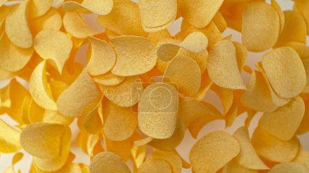 Téléchargez les photos : Congeler le mouvement des chips de pommes de terre frites volantes sur fond blanc - en image libre de droit