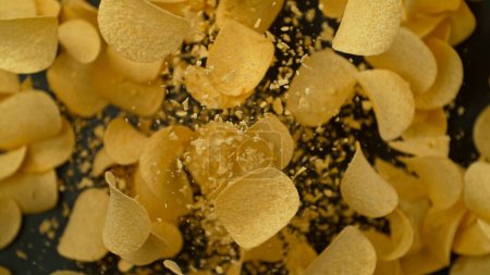 Téléchargez les photos : Congeler le mouvement des croustilles de pommes de terre frites volantes sur fond noir - en image libre de droit
