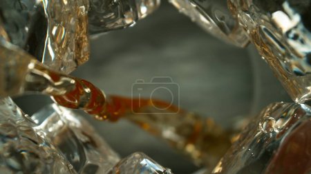 Téléchargez les photos : Plan de mouvement de gel de coulée liquide de whisky, macro, angle de vue unique du fond du verre - en image libre de droit
