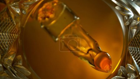 Photo for Freeze Motion Shot of Whiskey Liquid Pouring, Macro, Unique Angle of View from the Bottom of the Glass - Royalty Free Image