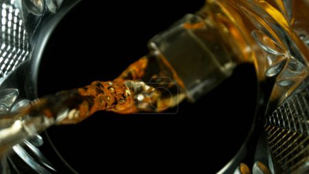 Freeze Motion Shot of Whiskey Liquid Gießen, Makro, einzigartiger Blickwinkel vom Boden des Glases