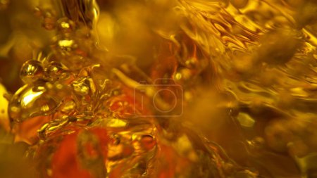 Téléchargez les photos : Plan de mouvement de gel de coulée liquide de whisky, macro, angle de vue unique du fond du verre - en image libre de droit