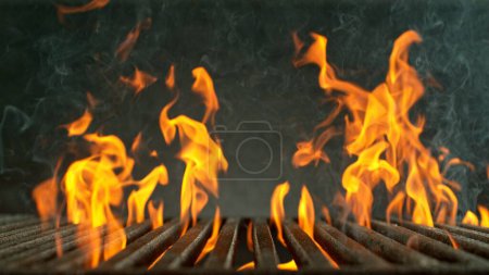 Photo for Close-up of cast-iron grate with fire flames, dark background - Royalty Free Image
