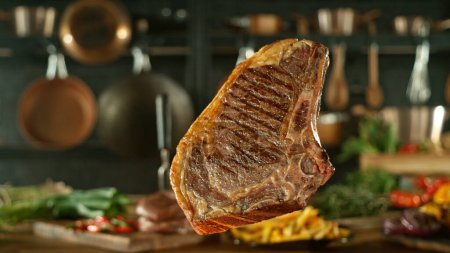 Photo for Close-up of tasty beef steak flying above cast-iron grate with fire flames - Royalty Free Image