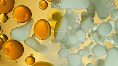 Freeze Motion Shot of Moving Oil and Milk Bubbles on Golden Background, Cosmetics Concept