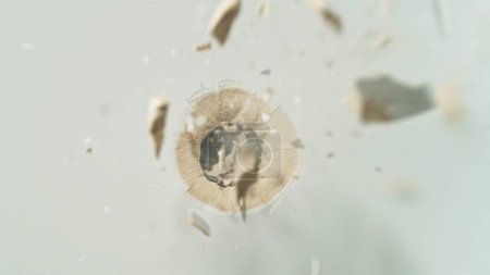 Photo for Freeze motion of gunshot through the stove, shattering against black background - Royalty Free Image
