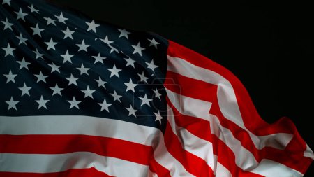 Foto de Primer plano de la bandera estadounidense sobre fondo negro, movimiento de congelación - Imagen libre de derechos