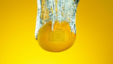 Foto de Congelar el movimiento de la caída de fruta fresca de limón en agua - Imagen libre de derechos