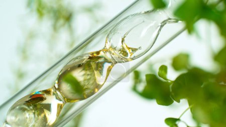 Obtener aceite esencial de sustancias naturales y flores. El aceite amarillo fluye en una espiral.