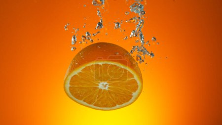 Foto de Congelar el movimiento de la caída de fruta de naranja fresca en agua - Imagen libre de derechos