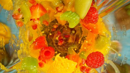 Téléchargez les photos : Congeler le mouvement de mélange des morceaux de fruits et légumes dans le mélangeur, plan supérieur - en image libre de droit