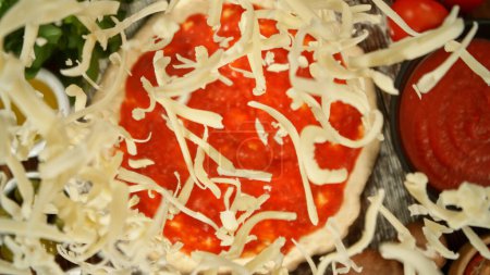 Foto de Super cámara lenta de la caída de varios ingredientes en la masa de pizza con sugo, vista superior hacia abajo - Imagen libre de derechos