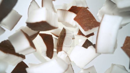 Photo for Fresh coconut pieces falling into cream, top down view - Royalty Free Image