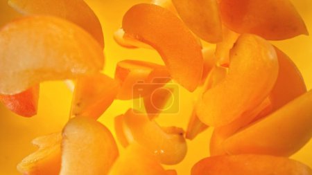 Photo for Fresh apricots pieces falling into water, top down view - Royalty Free Image