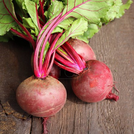 Fresh beetroot with leaves on a wooden background. Healthy food. Top view. Free space for your text.