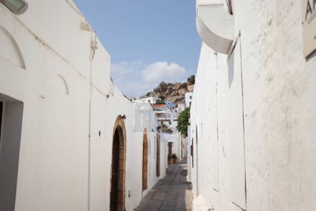 Enge Straße in Lindos Stadt auf der Insel Rhodos, Dodekanes, Griechenland. Schöne malerische alte weiße Häuser. Berühmtes Touristenziel in Südeuropa .