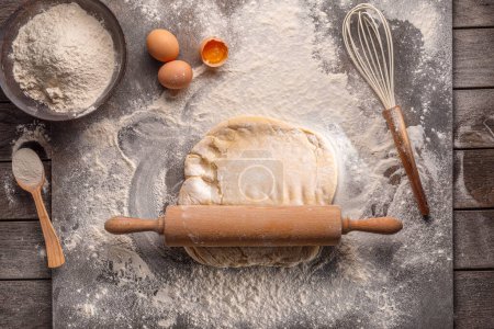 Téléchargez les photos : Prêt à cuire la pâte. Vue du dessus du plateau, rouleau à pâtisserie, farine et pâte. - en image libre de droit