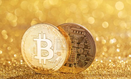 Gold bitcoin coins at the blazing gold background. Conceptual picture of digital money.