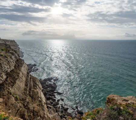 Foto de La costa rocosa, el océano y la luz del sol brillan a través de huecos en las nubes. Hermosa naturaleza fondo. - Imagen libre de derechos