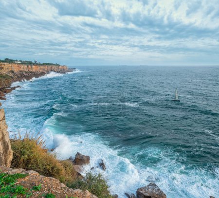 Foto de Hermoso cielo nublado y olas espumosas acercándose a la costa rocosa del océano Atlántico. Hermosa naturaleza de fondo de Portugal. - Imagen libre de derechos