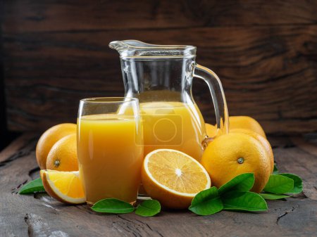 Foto de Frutas de naranja amarilla y zumo de naranja fresco aislados sobre fondo de madera oscura. - Imagen libre de derechos