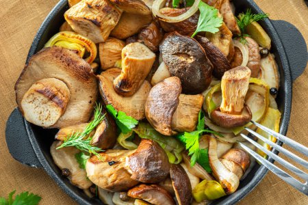 Photo for Cooked porcini mushrooms in the frying pan on the wooden table. Top view. - Royalty Free Image