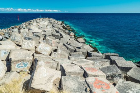 Téléchargez les photos : Portrait art graffiti d'artistes célèbres, musiciens et chanteurs sur des pierres de brise-lames dans le Santa Cruz de Tenerife. Photo éditoriale. - en image libre de droit