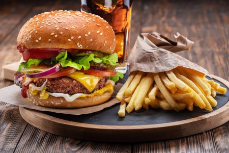 Photo for Tasty cheeseburger or hamburger, glass of cola and french fries on wooden tray close-up. - Royalty Free Image