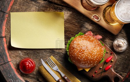Photo for Glasses of beer, hamburger and empty paper blank on old wooden barrel. Flat layer. - Royalty Free Image